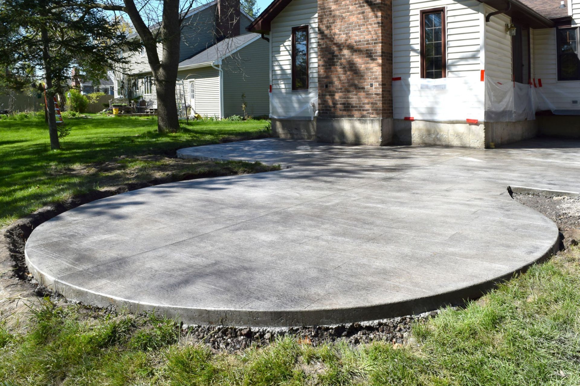 A custom-designed stamped concrete patio in Tampa, FL, featuring a circular shape and textured finish. Ideal for homeowners searching for ‘concrete patio Tampa’ or ‘concrete companies in Tampa’ to enhance their outdoor space.