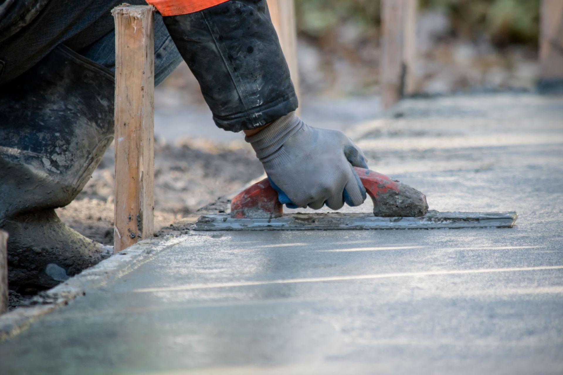 A skilled contractor smoothing freshly poured concrete with a trowel, ensuring a level and durable surface for a high-quality finish.