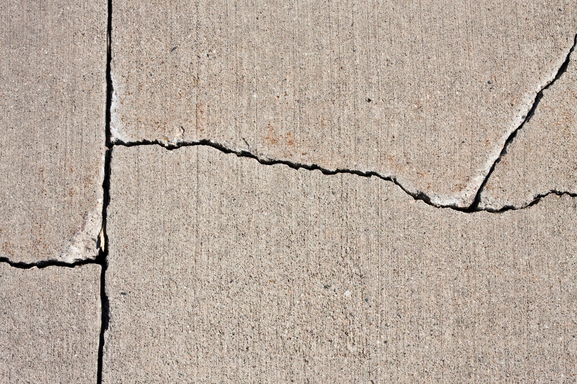 Close-up of a cracked concrete surface in need of repair and restoration.